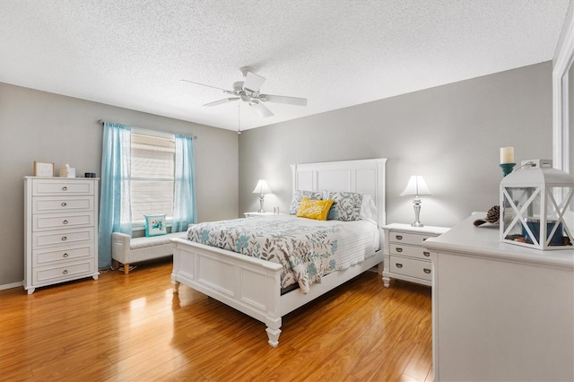 bedroom with ceiling fan, a textured ceiling, and light wood-type flooring