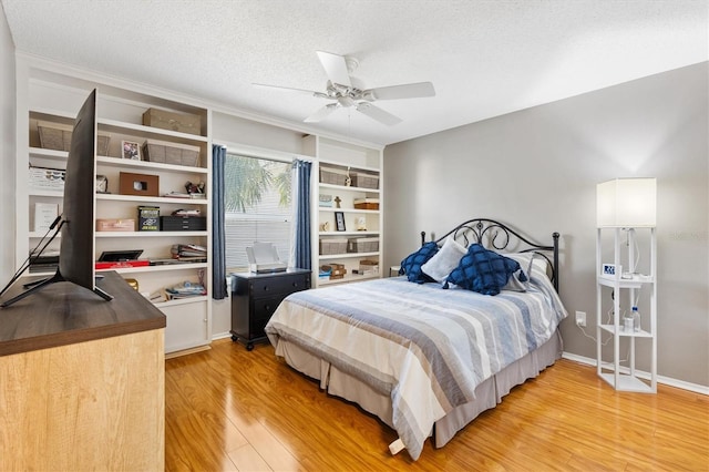 bedroom with ceiling fan, a textured ceiling, and light wood-type flooring