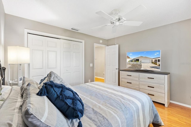 bedroom with a closet, ceiling fan, and light hardwood / wood-style flooring