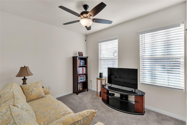 carpeted living room with ceiling fan and baseboards