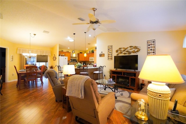 living room with lofted ceiling, dark hardwood / wood-style floors, and ceiling fan with notable chandelier