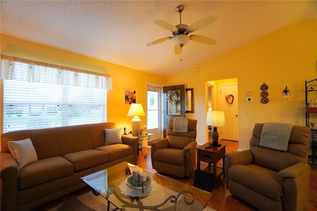 living room featuring hardwood / wood-style floors, a textured ceiling, vaulted ceiling, and ceiling fan