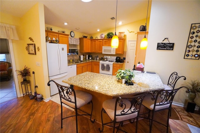 kitchen with vaulted ceiling, sink, hanging light fixtures, kitchen peninsula, and white appliances