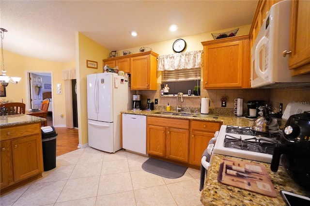 kitchen featuring sink, light tile patterned floors, pendant lighting, white appliances, and light stone countertops