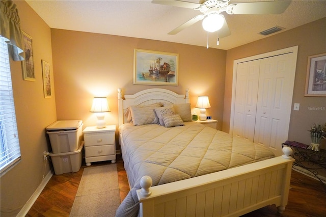 bedroom with dark hardwood / wood-style floors, ceiling fan, and a closet