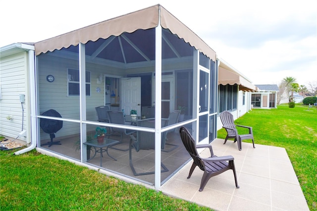 back of house with a yard, a sunroom, and a patio area