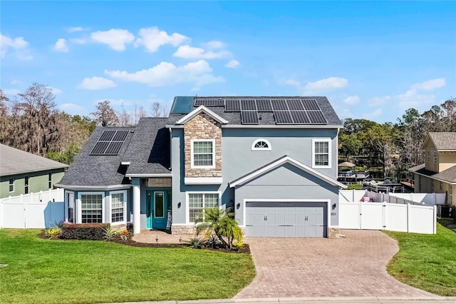 view of front property featuring a garage, a front yard, and solar panels