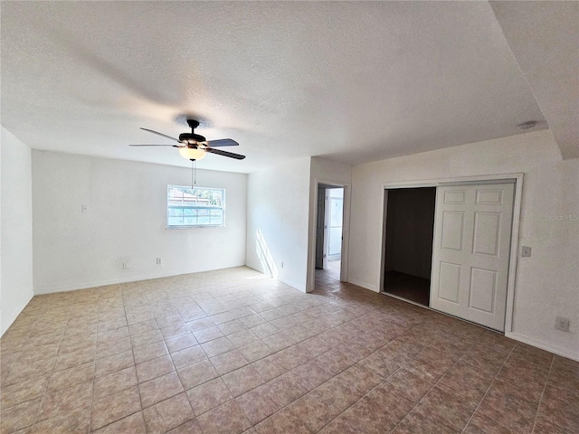 unfurnished room with a textured ceiling and ceiling fan