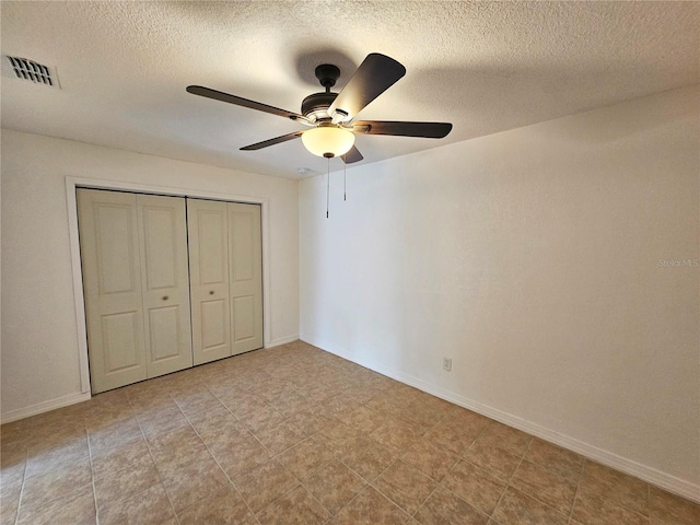 unfurnished bedroom featuring ceiling fan, a closet, and a textured ceiling