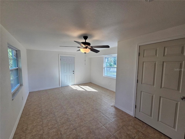 interior space with ceiling fan and a textured ceiling