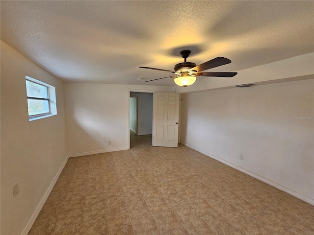 empty room featuring ceiling fan and a textured ceiling