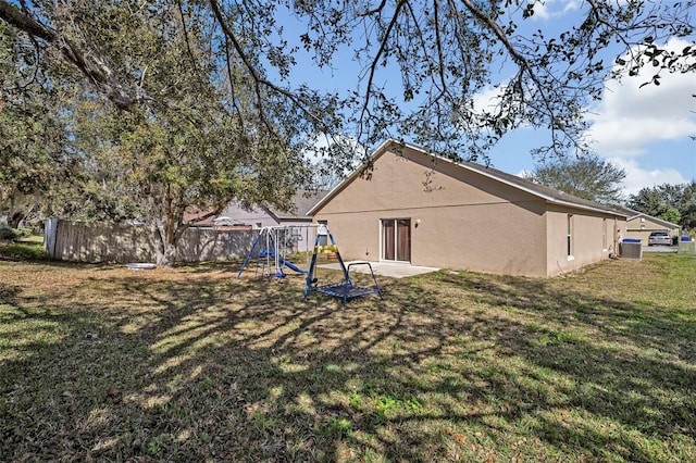 4078 Waltham Forest Dr, Tavares, FL 32778 - back of property with central AC unit, a playground, and a lawn