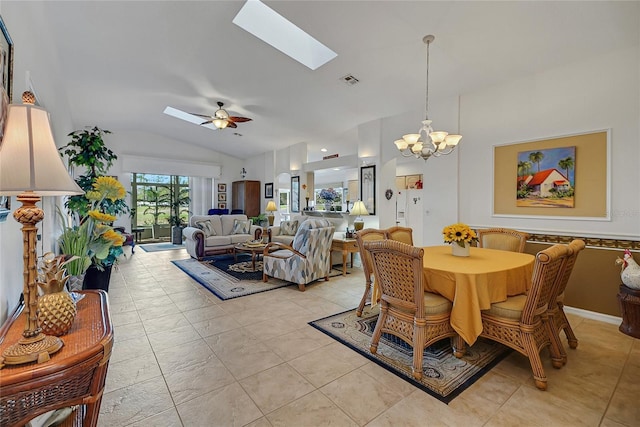 dining room featuring ceiling fan with notable chandelier and lofted ceiling with skylight