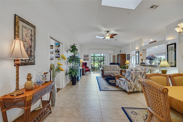 living room featuring ceiling fan and vaulted ceiling with skylight