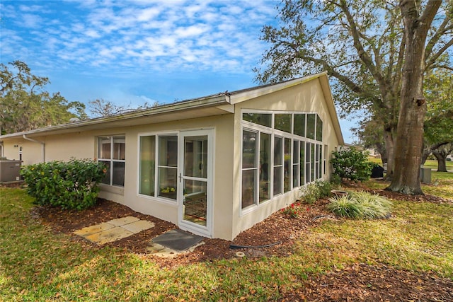 view of property exterior with a sunroom