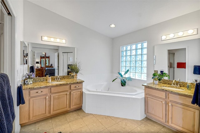 bathroom with vaulted ceiling, vanity, and tile patterned flooring