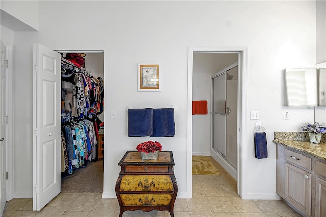 bathroom with vanity, tile patterned floors, and a shower with door