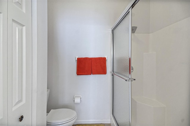 bathroom featuring walk in shower and toilet