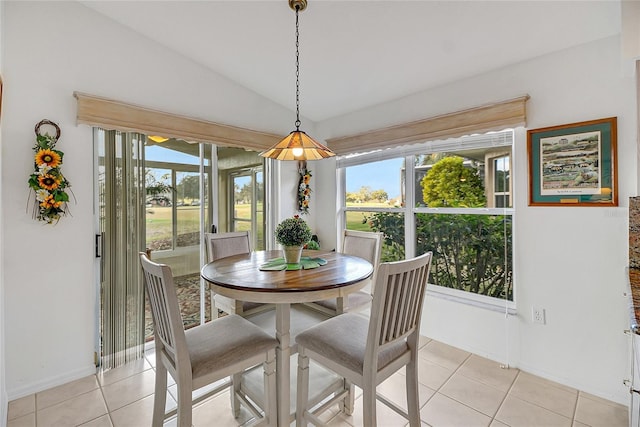 tiled dining area with vaulted ceiling