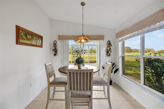 dining space featuring light tile patterned floors, a wealth of natural light, and vaulted ceiling