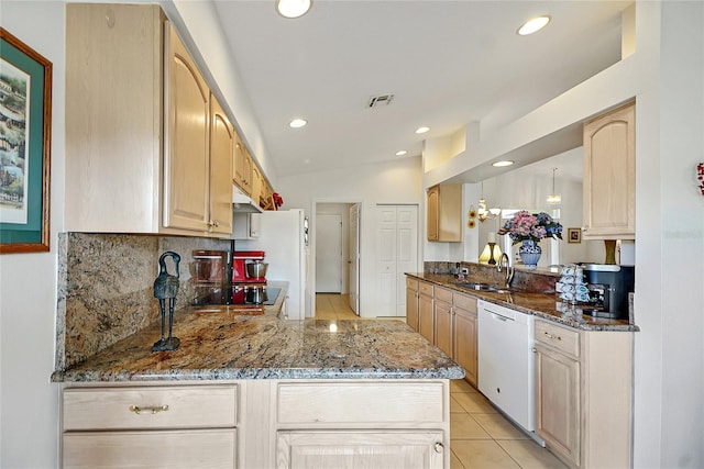 kitchen featuring stone counters, light brown cabinetry, sink, kitchen peninsula, and white appliances