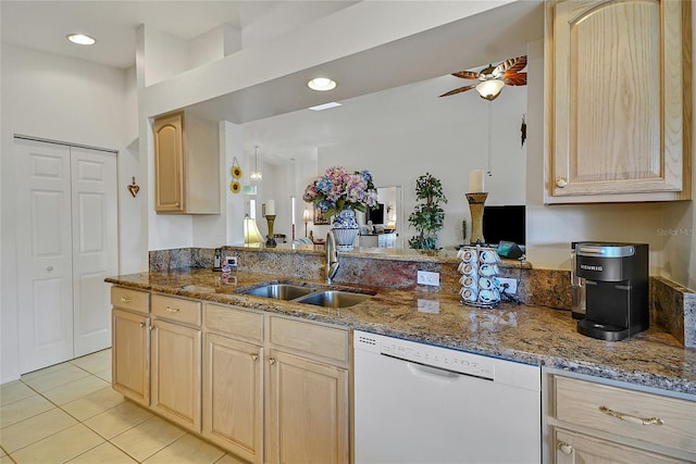 kitchen featuring dishwasher, sink, stone countertops, and light brown cabinetry