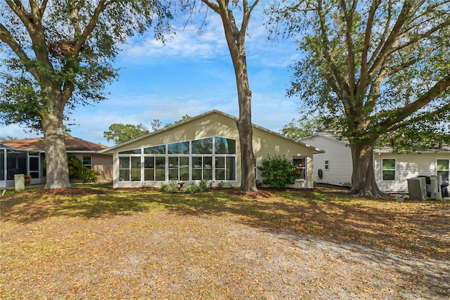 rear view of property with a sunroom and a lawn