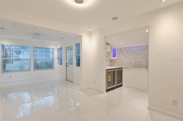 empty room featuring recessed lighting, marble finish floor, and baseboards