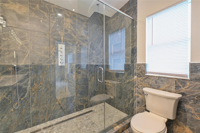 full bath with a marble finish shower, toilet, and tile walls