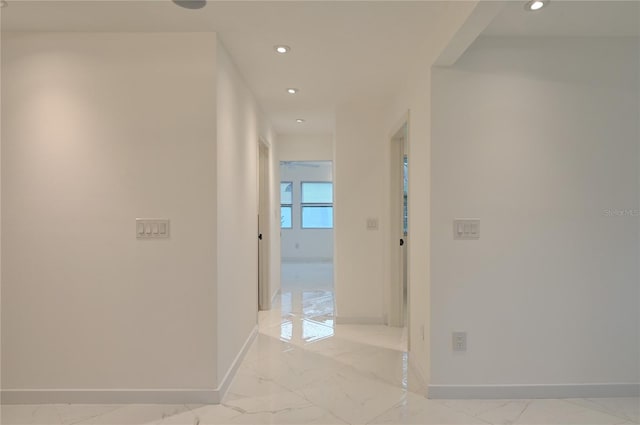 corridor featuring recessed lighting, baseboards, and marble finish floor