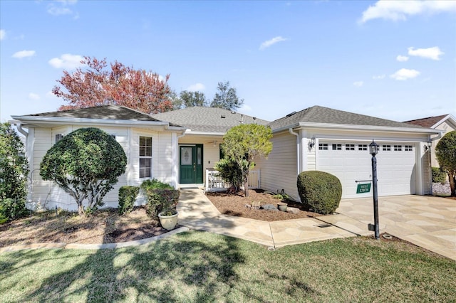 single story home featuring a garage and a front lawn