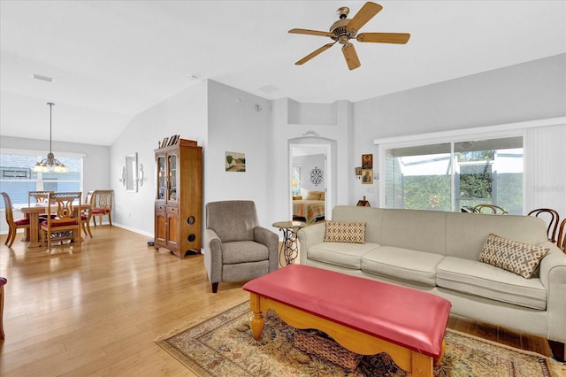 living room featuring ceiling fan, vaulted ceiling, light hardwood / wood-style floors, and a healthy amount of sunlight