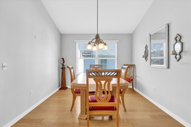 dining space with an inviting chandelier, lofted ceiling, and light hardwood / wood-style flooring