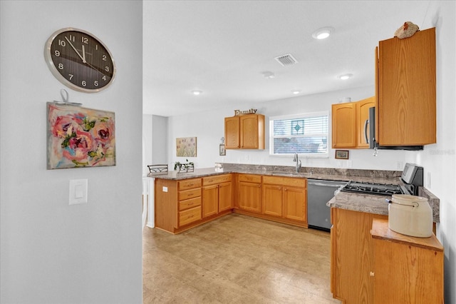 kitchen featuring light stone counters, sink, kitchen peninsula, and appliances with stainless steel finishes