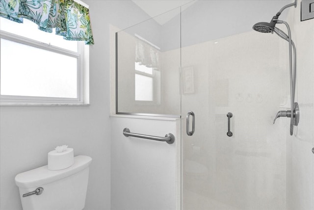 bathroom with a shower with door and toilet