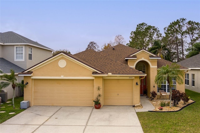 view of front facade featuring a garage, roof with shingles, driveway, and stucco siding