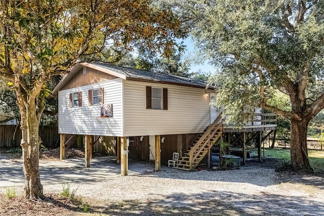 view of outdoor structure with a carport, driveway, and stairway