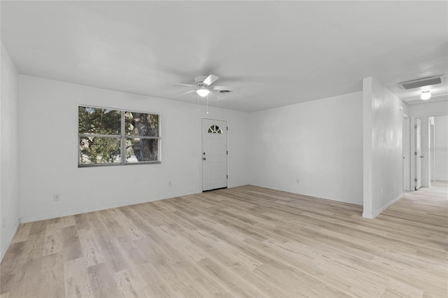 empty room featuring light wood-style floors, visible vents, and a ceiling fan