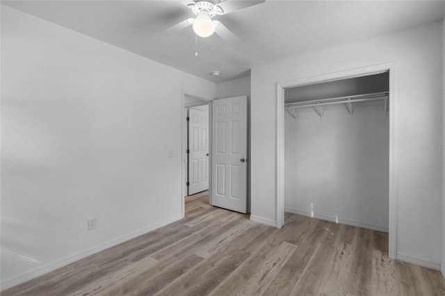 unfurnished bedroom with baseboards, a closet, a ceiling fan, and light wood-style floors