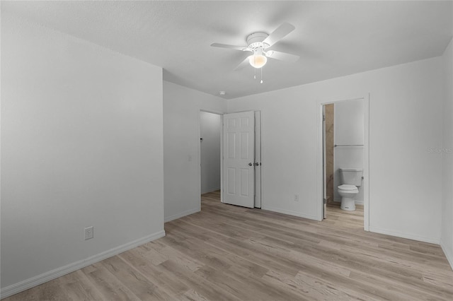 unfurnished bedroom featuring ceiling fan, connected bathroom, light wood-style flooring, and baseboards