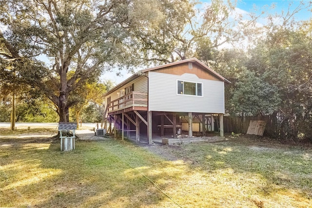 view of side of home with stairway, fence, a deck, a yard, and central AC