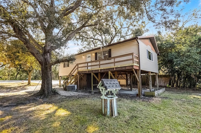 rear view of house with cooling unit, a lawn, stairway, and a wooden deck