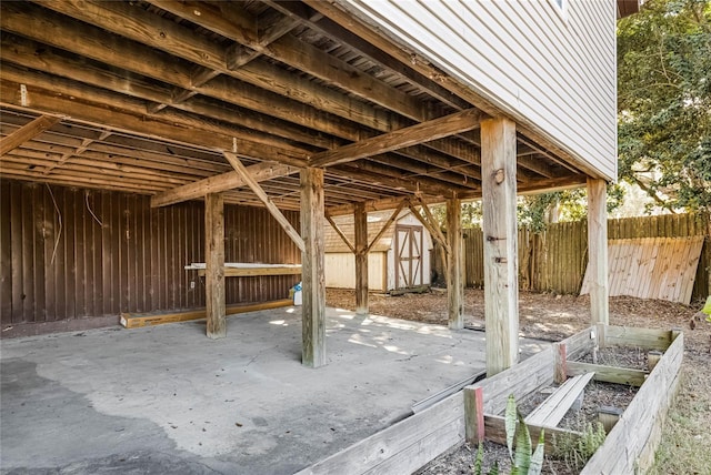 view of patio / terrace featuring a shed, an outdoor structure, fence, and a garden