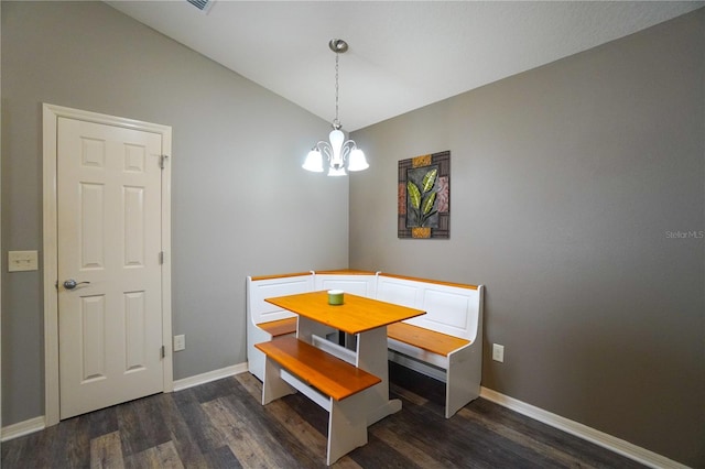 dining space featuring an inviting chandelier, vaulted ceiling, and dark hardwood / wood-style floors