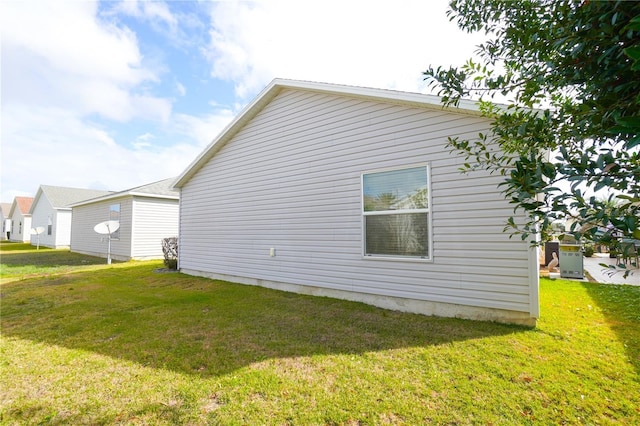 view of side of home with a yard