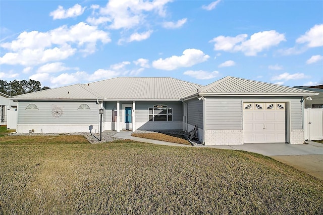 ranch-style home featuring metal roof, an attached garage, a front lawn, and concrete driveway