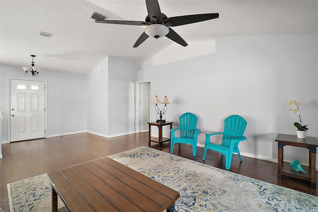 living area with baseboards, visible vents, wood finished floors, vaulted ceiling, and a textured ceiling