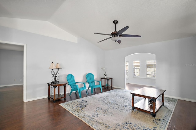 living area with baseboards, arched walkways, a ceiling fan, lofted ceiling, and wood finished floors