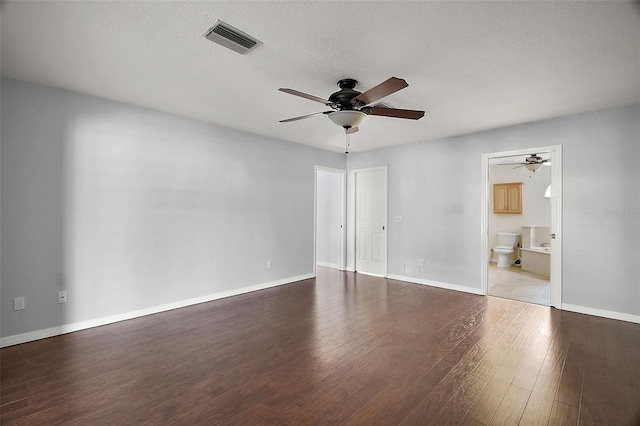 unfurnished room with a ceiling fan, visible vents, baseboards, and wood finished floors