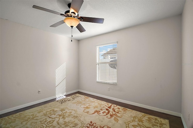 spare room with a textured ceiling, baseboards, and a ceiling fan